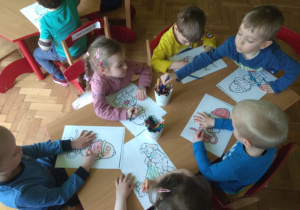 Dzieci kolorują kolorowankę - strażaka.