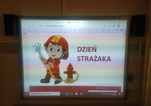 Dzieci oglądają film edukacyjny "Jedziemy na pomoc"