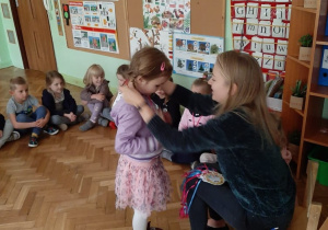 Pani wręcza dziewczynce medal z okazji Dnia Przedszkolaka.