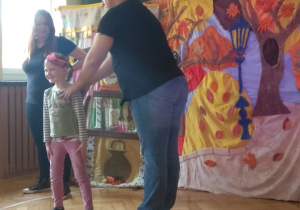 Aktorzy pokazują dziewczynce pozycję bezpieczną podczas ataku psa.