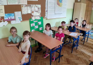 Dzieci siedzą w ławkach