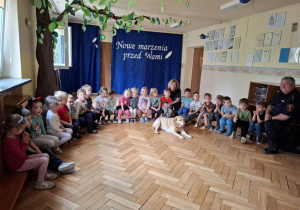 Dzieci pozują razem z psem i strażnikiem
