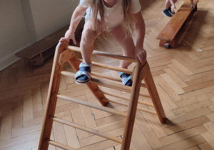 Dziewczynka przechodzi przez drabinkę