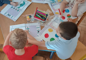 Dzieci wykonują zadania w książce