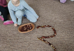 Dzieci układają z kasztanów