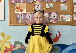 Dziewczynka pozuje w stroju pszczółki