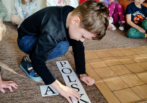 Chłopiec układa napis