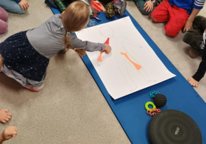 Dziewczynka nakleja naklejkę na postać człowieka