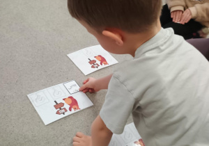 Chłopiec układa odpowiedni obrazek