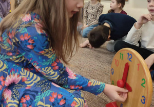 Dziewczynka ustawia godzinę