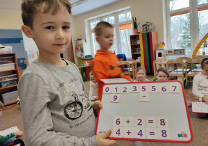 Chłopiec pokazuje tablicę z liczbami
