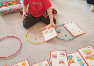 Chłopiec układa obrazek z odpowiednią liczbą