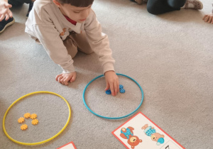 Chłopiec układa klocki w obręczy