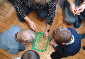 Dziadkowie z wnukami nakładają płatki na patyczek