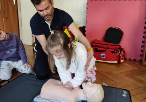 Dziewczynka wykonuje ćwiczenie na fantomie