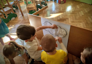 Dzieci przyklejają watę