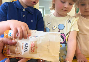 Chłopiec wsypuje mąkę