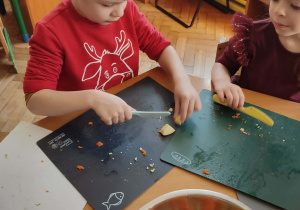 Chłopiec kroi warzywa