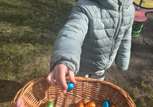 Dziecko wrzuca jajka do koszyczka