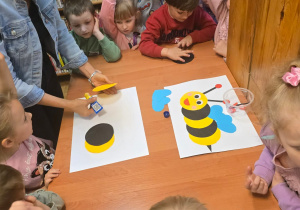 Dzieci wyklejają pszczołę