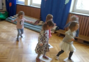 Dzieci biegają po sali gimnastycznej z obrazkami.