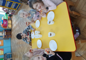 Zdjęcie przedstawia grupę dzieci, które jedzą pizzę.