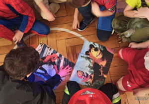 Zdjęcie przedstawia grupę chłopców układających puzzle.