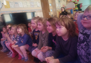 Zdjęcie przedstawia grupę dzieci oglądających z zaciekawieniem przedstawienie