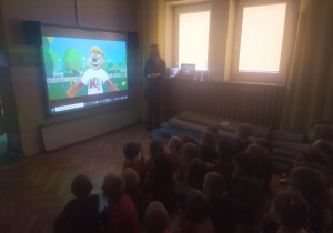 Zdjęcie przedstawia grupę dzieci oglądających film edukacyjny "Dbaj o ruch i odżywianie"