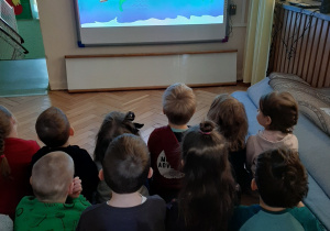 Grupa dzieci ogląda film edukacyjny o wodzie.