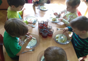 Dzieci jedzą zielony posiłek- zupę brokułową.