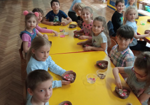 Dzieci dekorują czekoladę ulubionymi dodatkami.