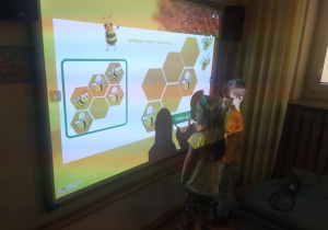 Dzieci wykonją zadanie na tablicy interaktywnej.