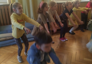 Grupa dzieci tańczy do piosenki.