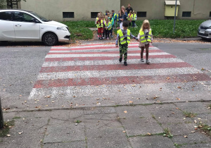 Dzieci przechodzą przez przejście dla pieszych.