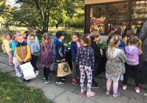 Dzieci kupują owoce w zieleniaku.