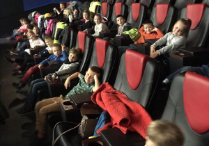 Dzieci czekają na seans w sali kinowej.