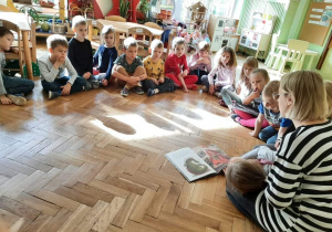 Mama Kaliny czyta dzieciom książkę.