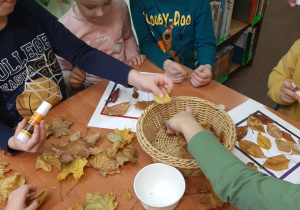 Dzieci wykonują ramki z suszonych liści.