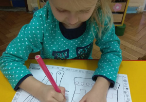 Dziewczynka rysuje grzebień po śladzie.