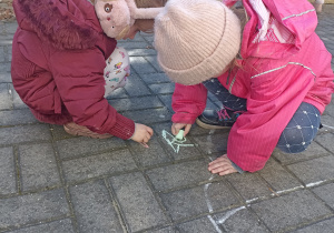Dzieci rysują na tarasie kredą.