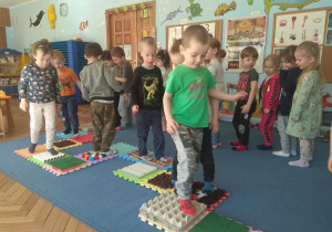 Dzieci przechodzą przez ścieżkę sensoryczną.