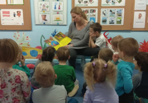 Mama czyta dzieciom książkę.