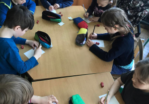 Dzieci zapisują działania matematyczne na kartce.