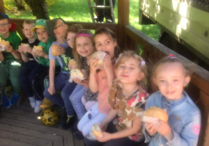 Dzieci jedzą kanapki w altance w parku