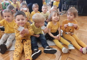 Dzieci ubrane na żółto pokazują bilety do kina