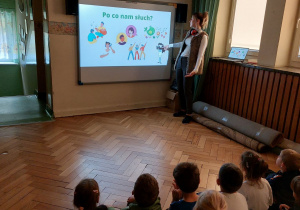 Dzieci oglądają prezentację mutlimedialną na temat narządu słuchu.