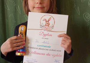 Dziewczynka z dyplomem za udział w konkursie .