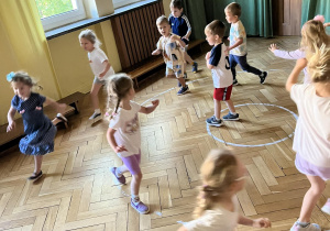 Dzieci biegają na sali gimnastycznej.