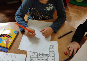 Chłopiec rysuje według kodu.
